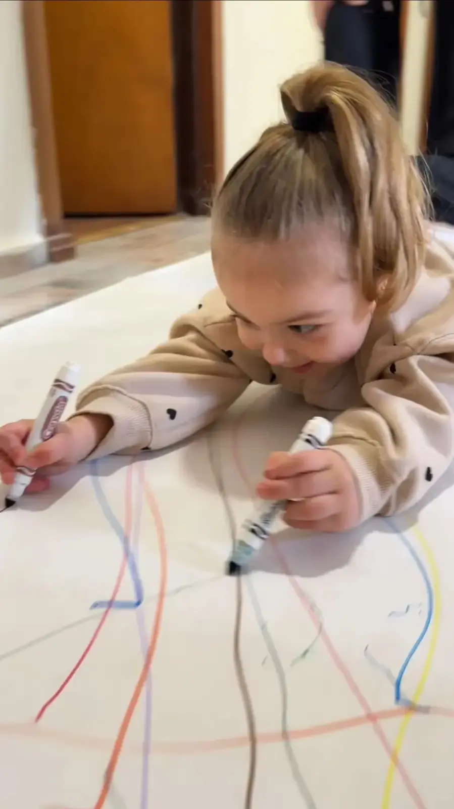 Niña dibujando libremente sobre una gran hoja
