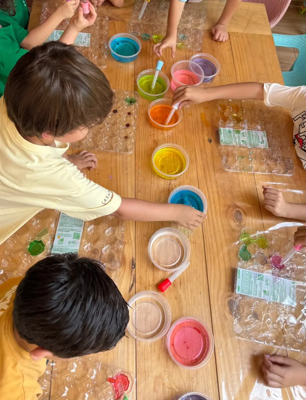 Niñas y niños explorando mezclas de colores con goteros